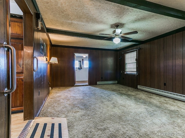 interior space featuring beam ceiling, light colored carpet, a baseboard heating unit, and wood walls