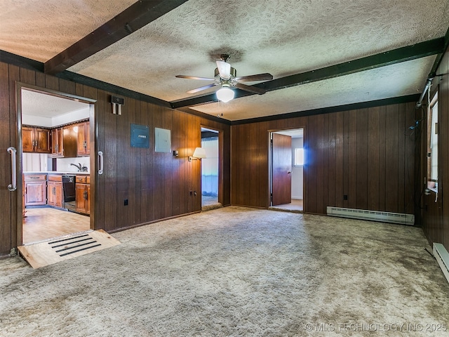 unfurnished living room with baseboard heating, light colored carpet, wood walls, and beamed ceiling