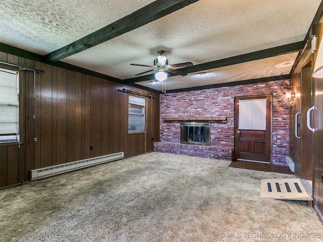 unfurnished living room featuring a baseboard radiator, a textured ceiling, carpet floors, beamed ceiling, and wooden walls