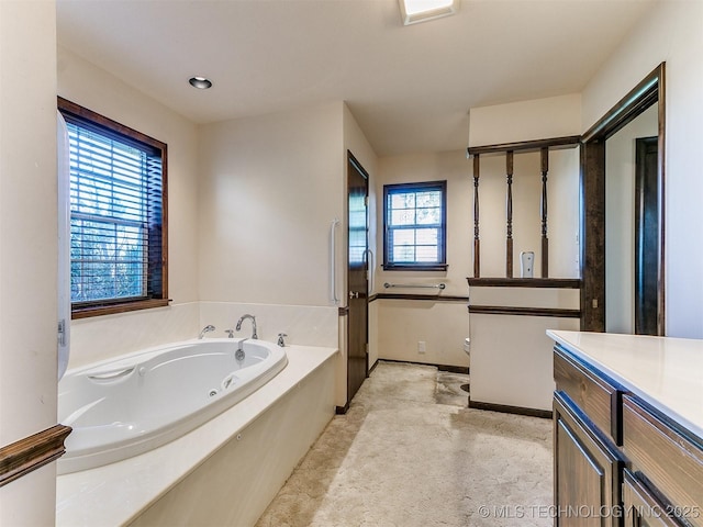 bathroom featuring a washtub and vanity