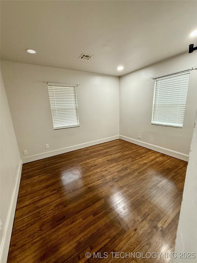 unfurnished room with dark wood-type flooring