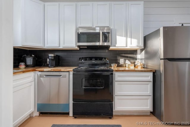 kitchen with stainless steel appliances, wooden counters, tasteful backsplash, and white cabinets