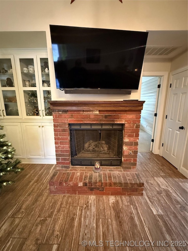 interior details with hardwood / wood-style flooring and a brick fireplace