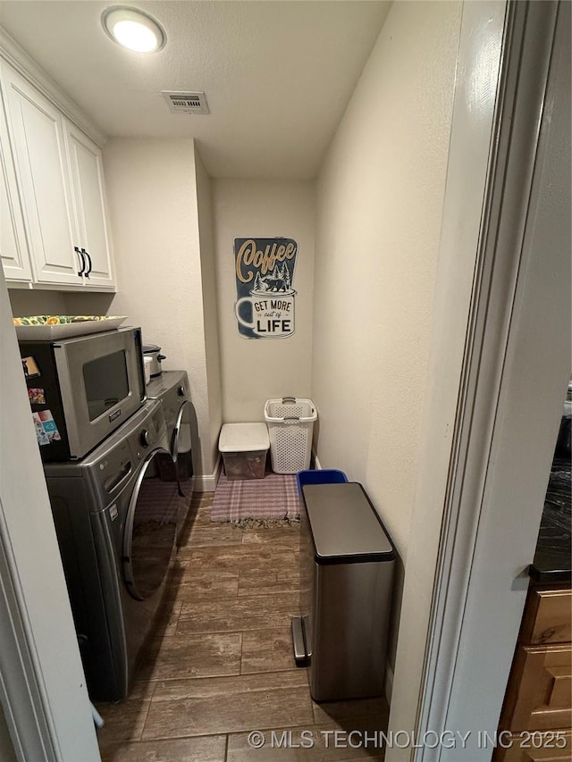 laundry room with cabinets, dark hardwood / wood-style flooring, and independent washer and dryer