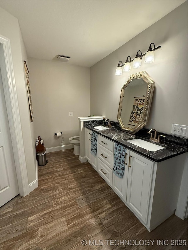 bathroom with wood-type flooring, toilet, and vanity