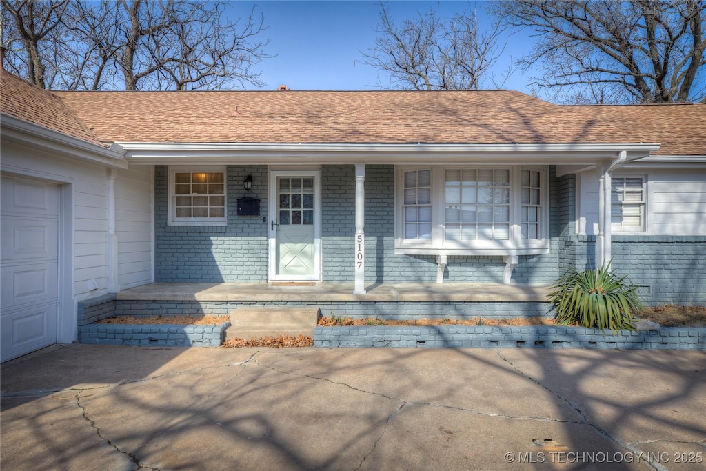 view of exterior entry featuring covered porch