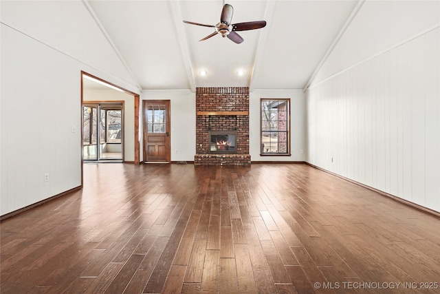 unfurnished living room featuring ceiling fan, a brick fireplace, vaulted ceiling with beams, and dark hardwood / wood-style floors