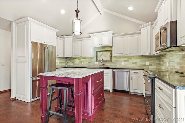 kitchen with a kitchen breakfast bar, white cabinets, a center island, and appliances with stainless steel finishes