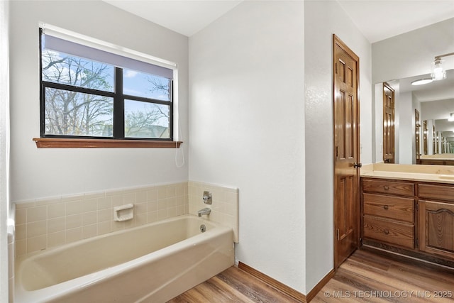 bathroom with vanity, a tub, and hardwood / wood-style floors