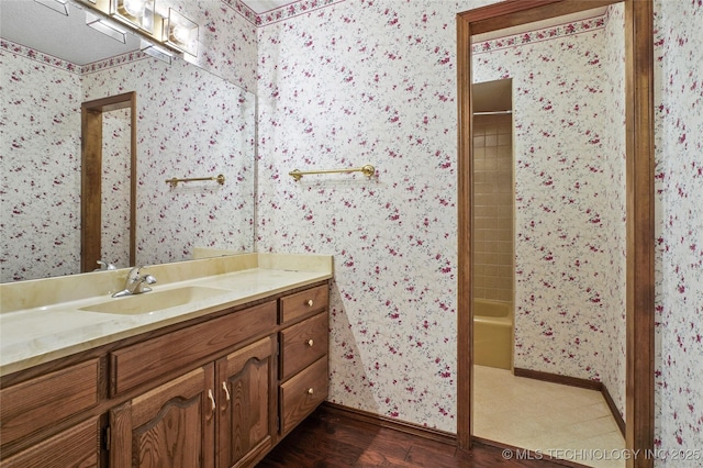 bathroom with vanity, hardwood / wood-style flooring, and bathtub / shower combination