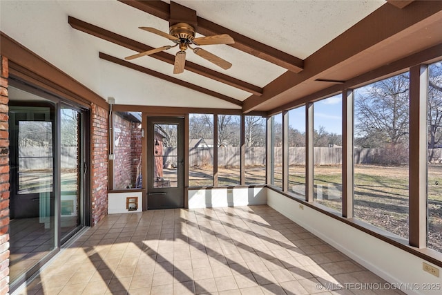 unfurnished sunroom with plenty of natural light and lofted ceiling with beams