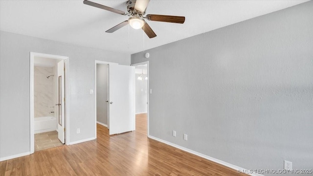 unfurnished bedroom featuring ensuite bathroom, ceiling fan, and light wood-type flooring