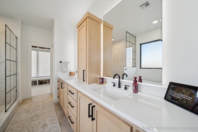 bathroom featuring walk in shower, tile patterned floors, plenty of natural light, and vanity