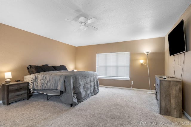 carpeted bedroom featuring ceiling fan and a textured ceiling