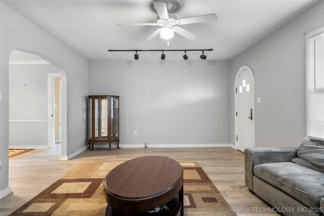 living room featuring ceiling fan, light hardwood / wood-style floors, and rail lighting