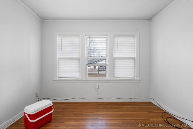 empty room with dark wood-type flooring and crown molding