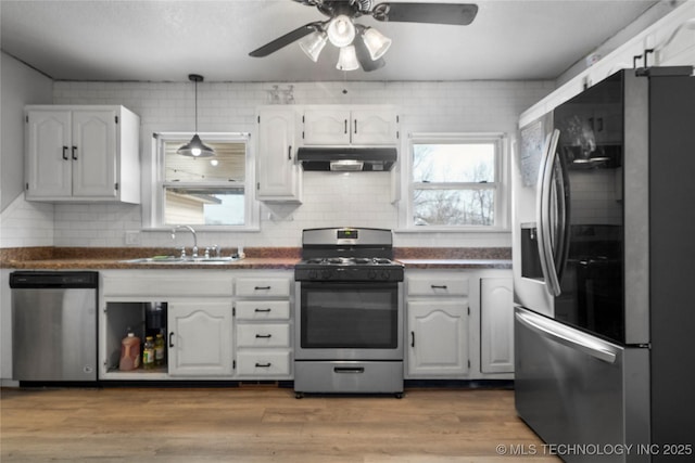 kitchen featuring stainless steel appliances, backsplash, white cabinetry, and sink