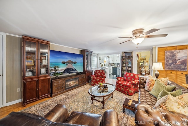 living room featuring ceiling fan, a fireplace, and hardwood / wood-style floors