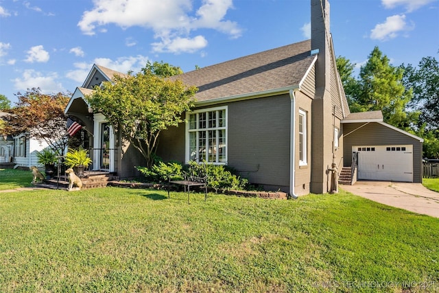 view of front of property featuring a front yard, an outbuilding, and a garage