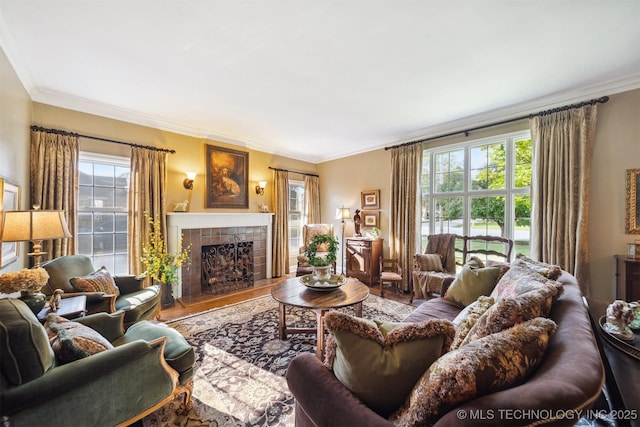 living room with hardwood / wood-style flooring, ornamental molding, and a tiled fireplace