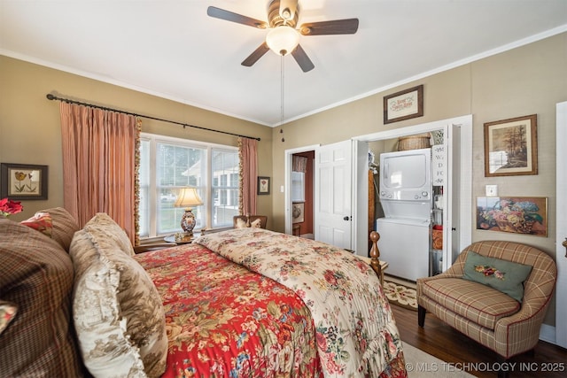 bedroom featuring ceiling fan, stacked washing maching and dryer, wood-type flooring, and ornamental molding