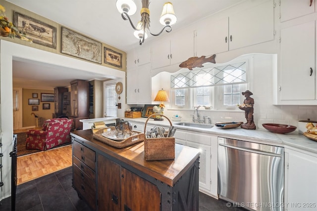 kitchen with pendant lighting, stainless steel dishwasher, sink, a healthy amount of sunlight, and white cabinets