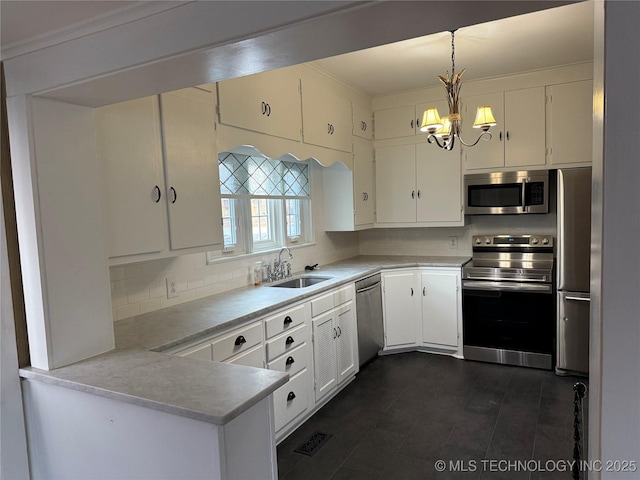 kitchen with tasteful backsplash, pendant lighting, sink, appliances with stainless steel finishes, and white cabinets