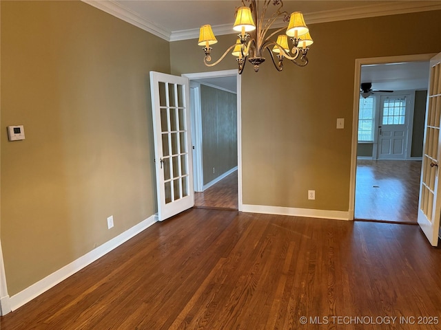 empty room featuring dark wood-type flooring, ceiling fan with notable chandelier, and crown molding