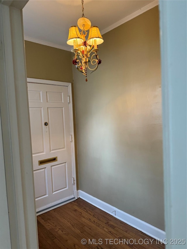 spare room featuring an inviting chandelier, ornamental molding, and dark hardwood / wood-style flooring