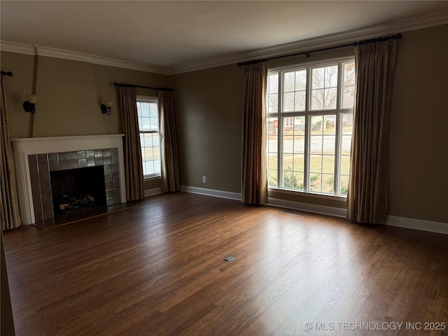 unfurnished living room with a tiled fireplace, dark hardwood / wood-style flooring, and ornamental molding