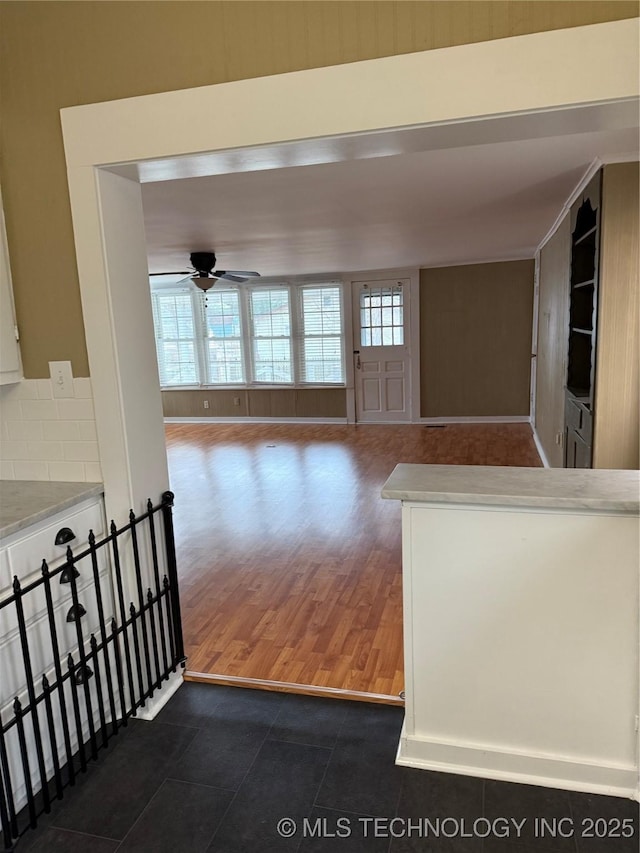 interior space with ceiling fan and dark tile patterned flooring