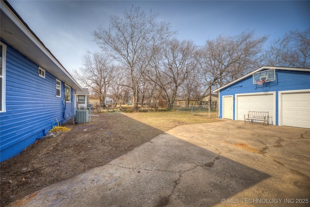 view of yard featuring cooling unit, an outdoor structure, and a garage