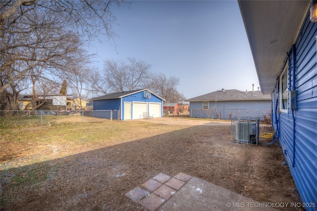 view of yard featuring a garage, an outbuilding, and cooling unit