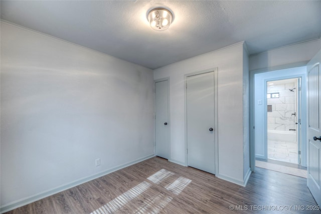 unfurnished bedroom featuring light wood-type flooring and a textured ceiling