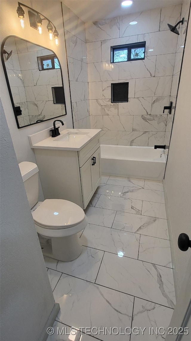 full bathroom featuring toilet, vanity, and tiled shower / bath