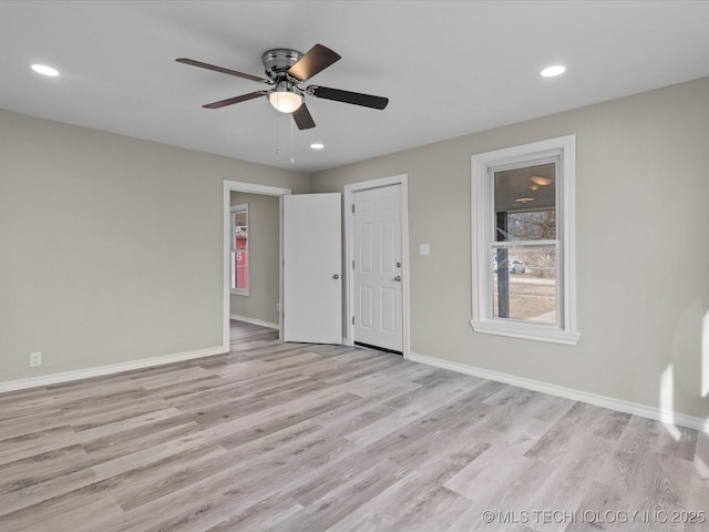 empty room with ceiling fan and light hardwood / wood-style flooring