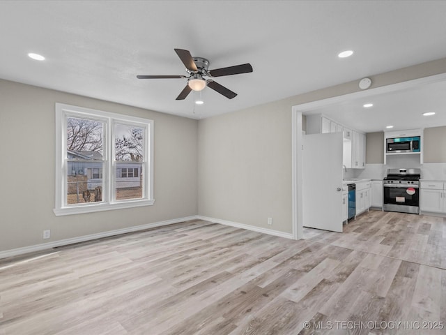 unfurnished living room with light wood-type flooring, ceiling fan, and sink