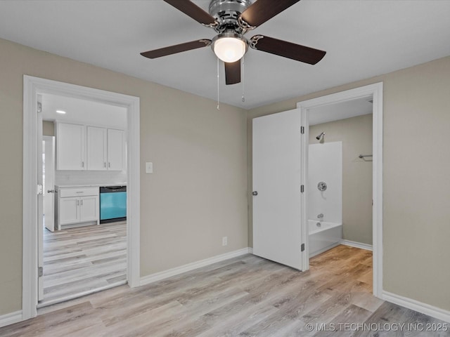 unfurnished bedroom with ceiling fan, ensuite bathroom, and light hardwood / wood-style flooring