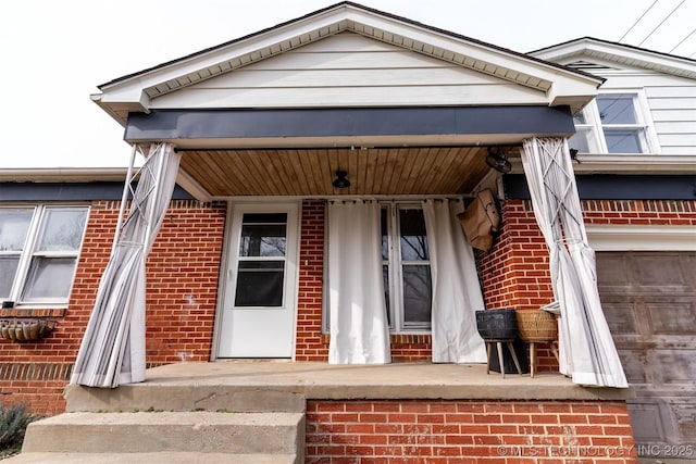 entrance to property with a garage and a porch