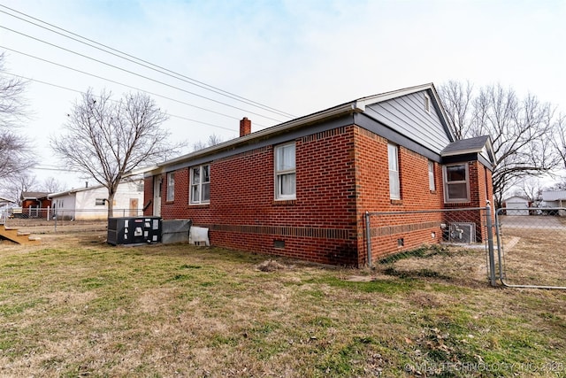 view of side of home with central AC unit and a lawn