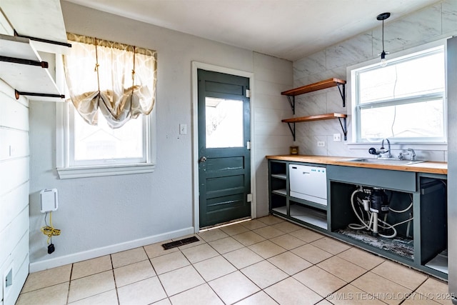 kitchen with decorative light fixtures, sink, butcher block countertops, and dishwasher