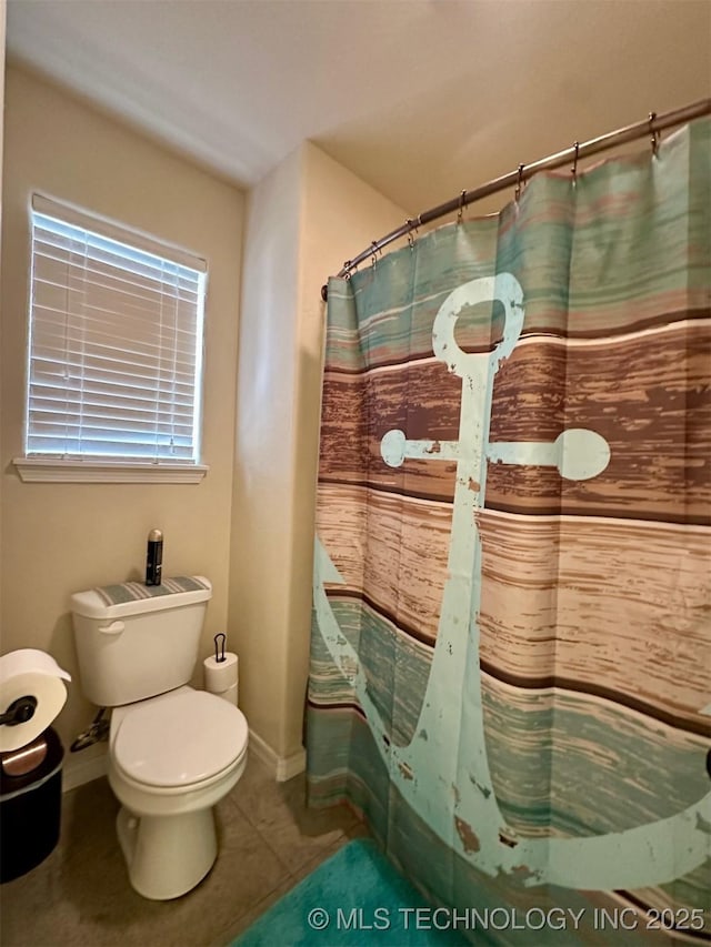 bathroom featuring toilet, a shower with curtain, and tile patterned flooring