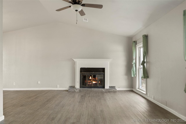 unfurnished living room featuring ceiling fan, a healthy amount of sunlight, vaulted ceiling, and dark wood-type flooring