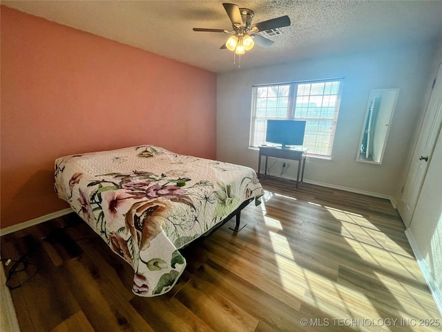 bedroom featuring hardwood / wood-style floors, a textured ceiling, and ceiling fan