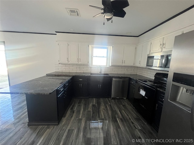 kitchen featuring white cabinetry, stainless steel appliances, decorative backsplash, sink, and kitchen peninsula