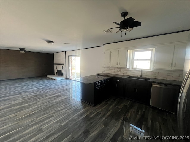 kitchen with tasteful backsplash, dishwasher, sink, and white cabinetry