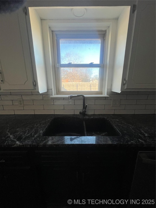 kitchen with sink, backsplash, and white cabinets