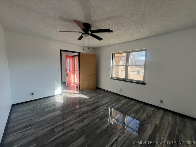 unfurnished bedroom with ceiling fan, dark wood-type flooring, and a textured ceiling