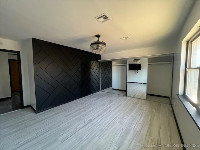 unfurnished bedroom featuring light wood-type flooring and a closet