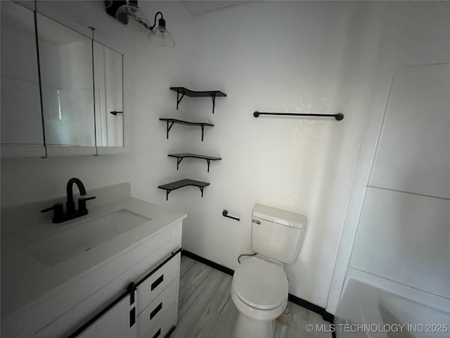 bathroom with hardwood / wood-style flooring, toilet, vanity, and walk in shower